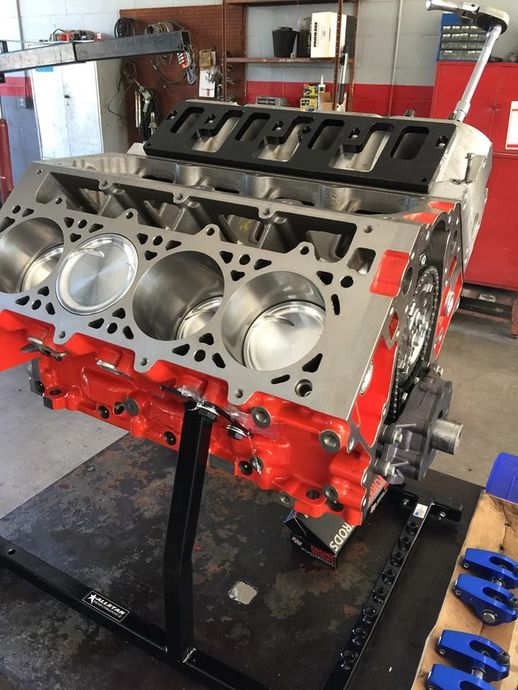 A man is working on a car engine with a wrench