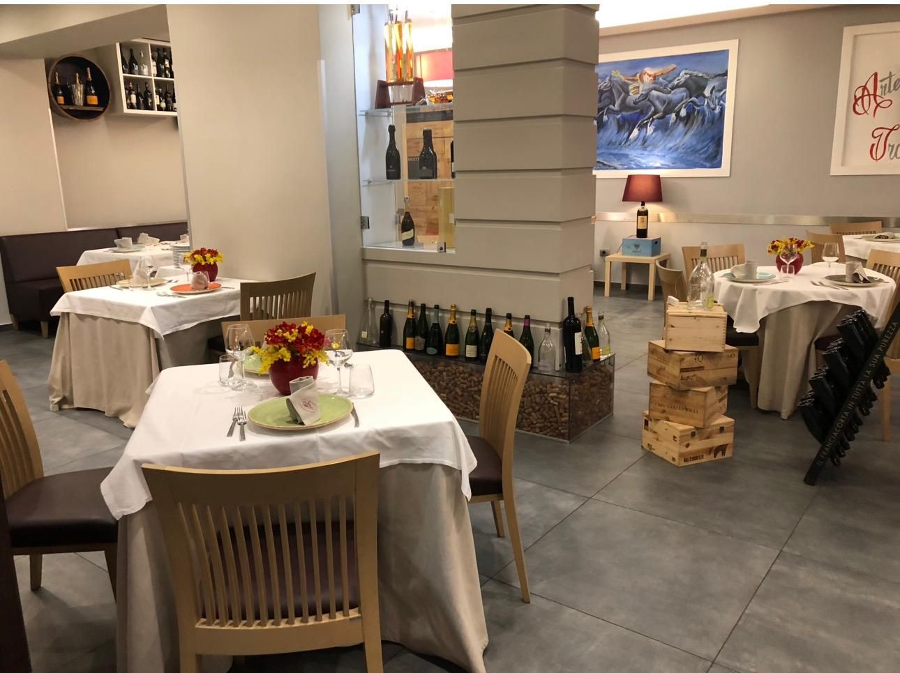 Antipasto di sushi su un piatto nero con una bottiglia di vino su una tovaglia bianca a un tavolo da pranzo formale