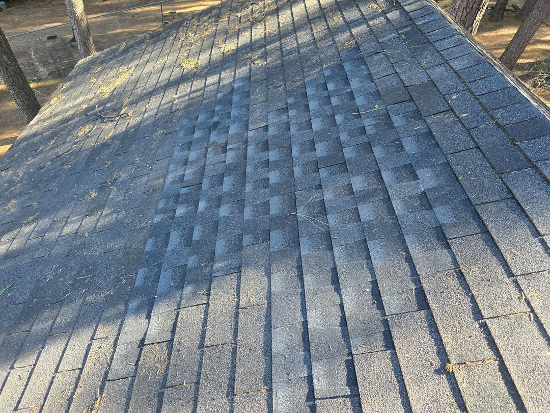 Snow-dusted wooden deck boards in sunlight, with long shadows across the planks