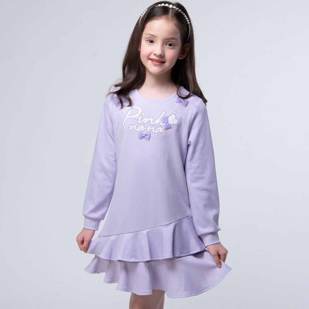 身穿淡紫色洋裝、頭戴珍珠頭帶的女孩面帶微笑。