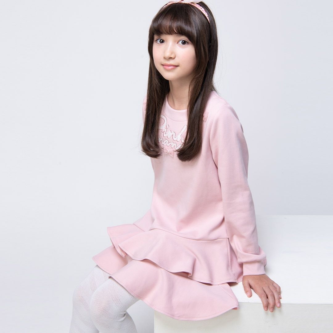 身穿淡紫色洋裝、頭戴珍珠頭帶的女孩面帶微笑。