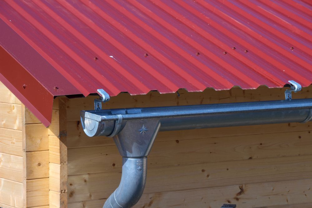 A Close Up Of A Gutter On A Red Roof — Roof & Guttering Solutions In Saratoga, NSW