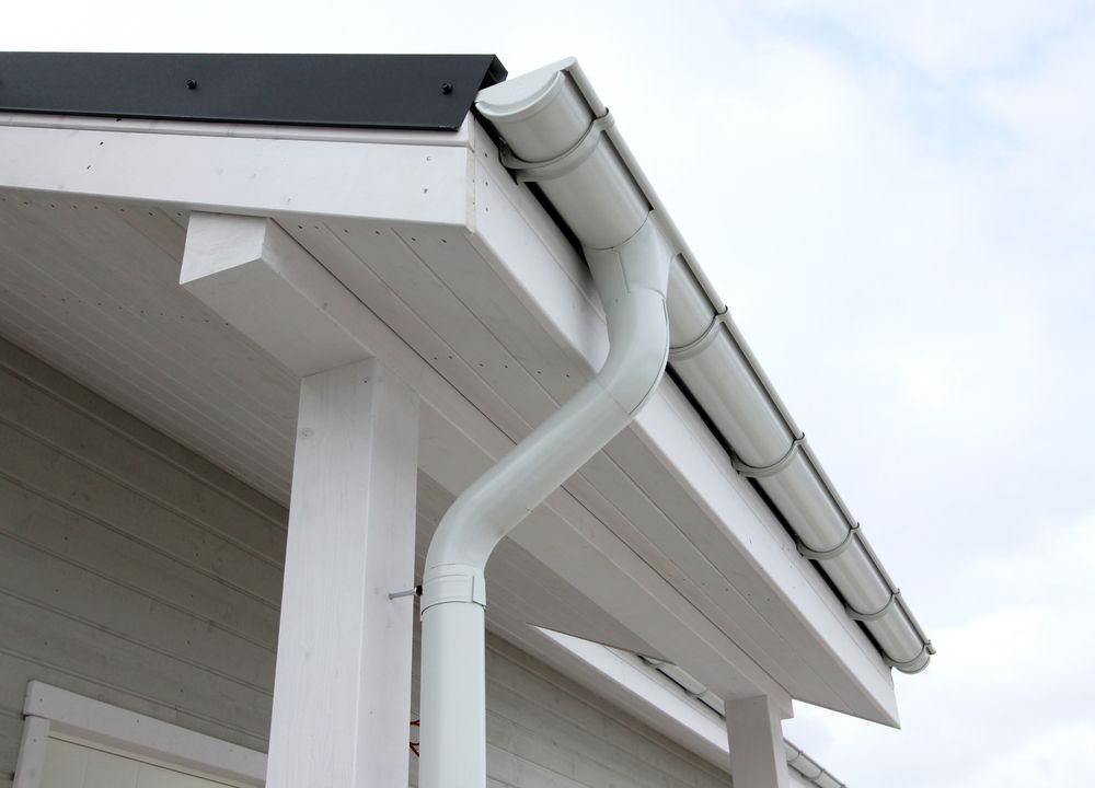 A White Gutter On The Side Of A House — Roof & Guttering Solutions In Woy Woy, NSW