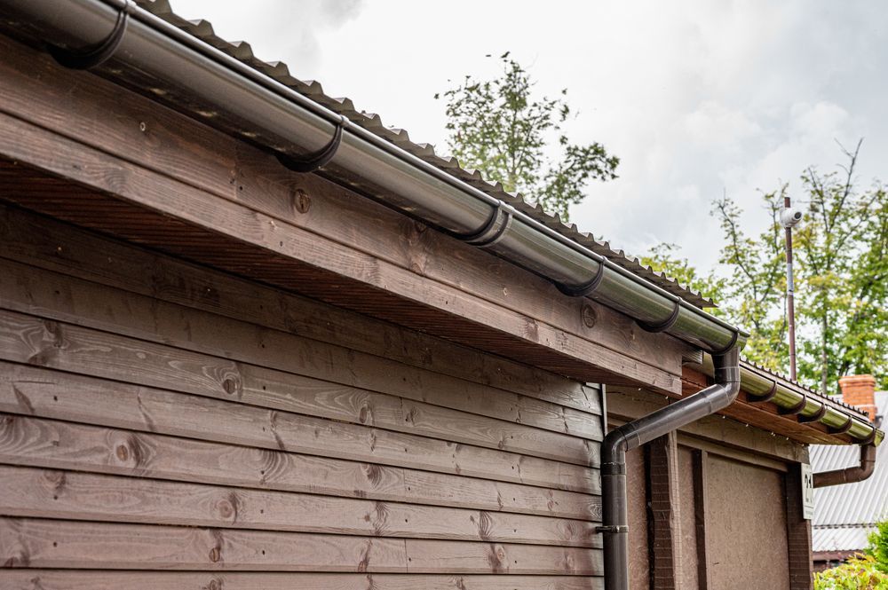There Is A Gutter On The Side Of A Wooden Building — Roof & Guttering Solutions In Saratoga, NSW