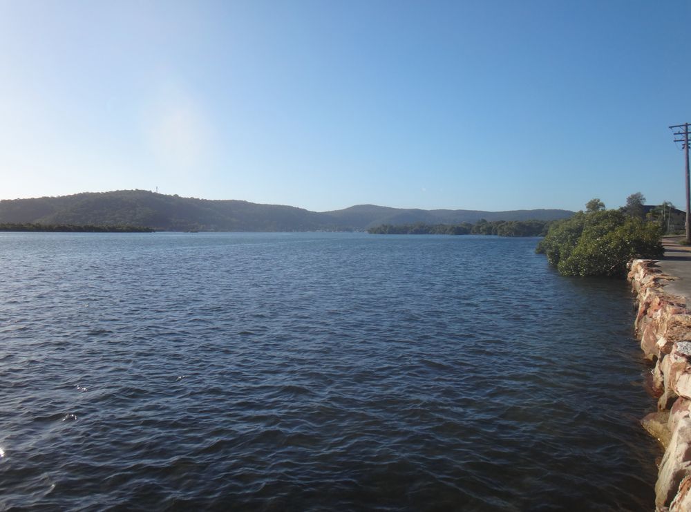 A Large Body Of Water With Mountains In The Background — Roof & Guttering Solutions In Saratoga, NSW