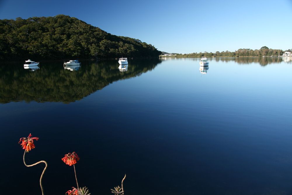 A Lake With Boats In It And A Mountain In The Background — Roof & Guttering Solutions In Woy Woy, NSW