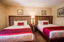 Twin beds with red and white bedding in a cozy hotel room