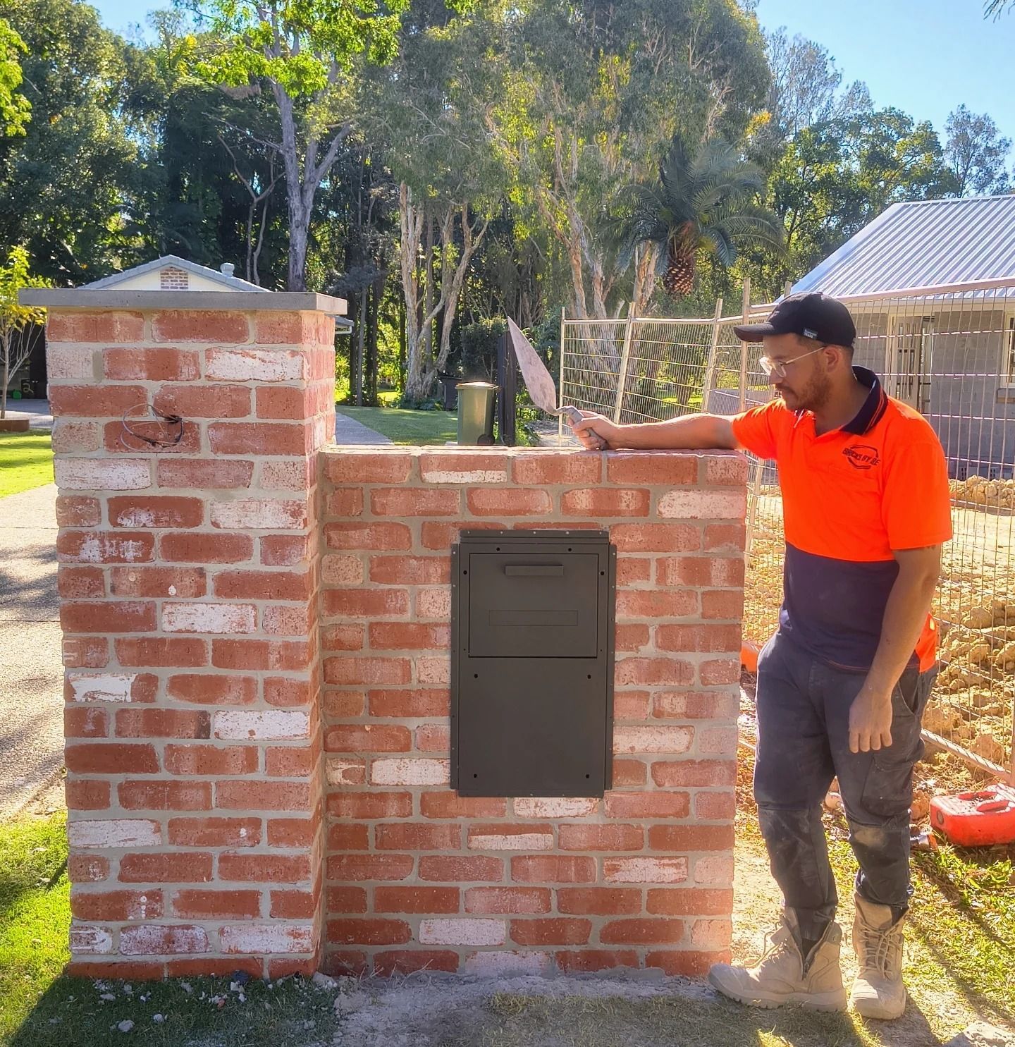 Man Leaning Against A Brick Mailbox In Front Of A Tree-lined Yard — Bricks By Dre In Nerang, QLD