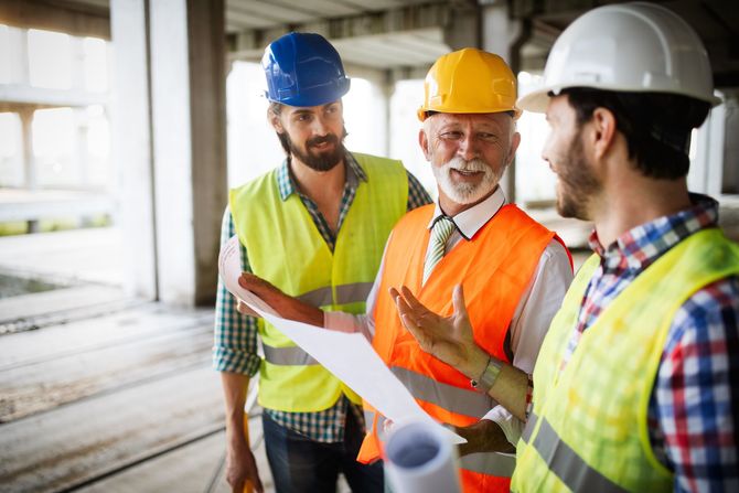 A group of construction workers are standing next to each other on a construction site.