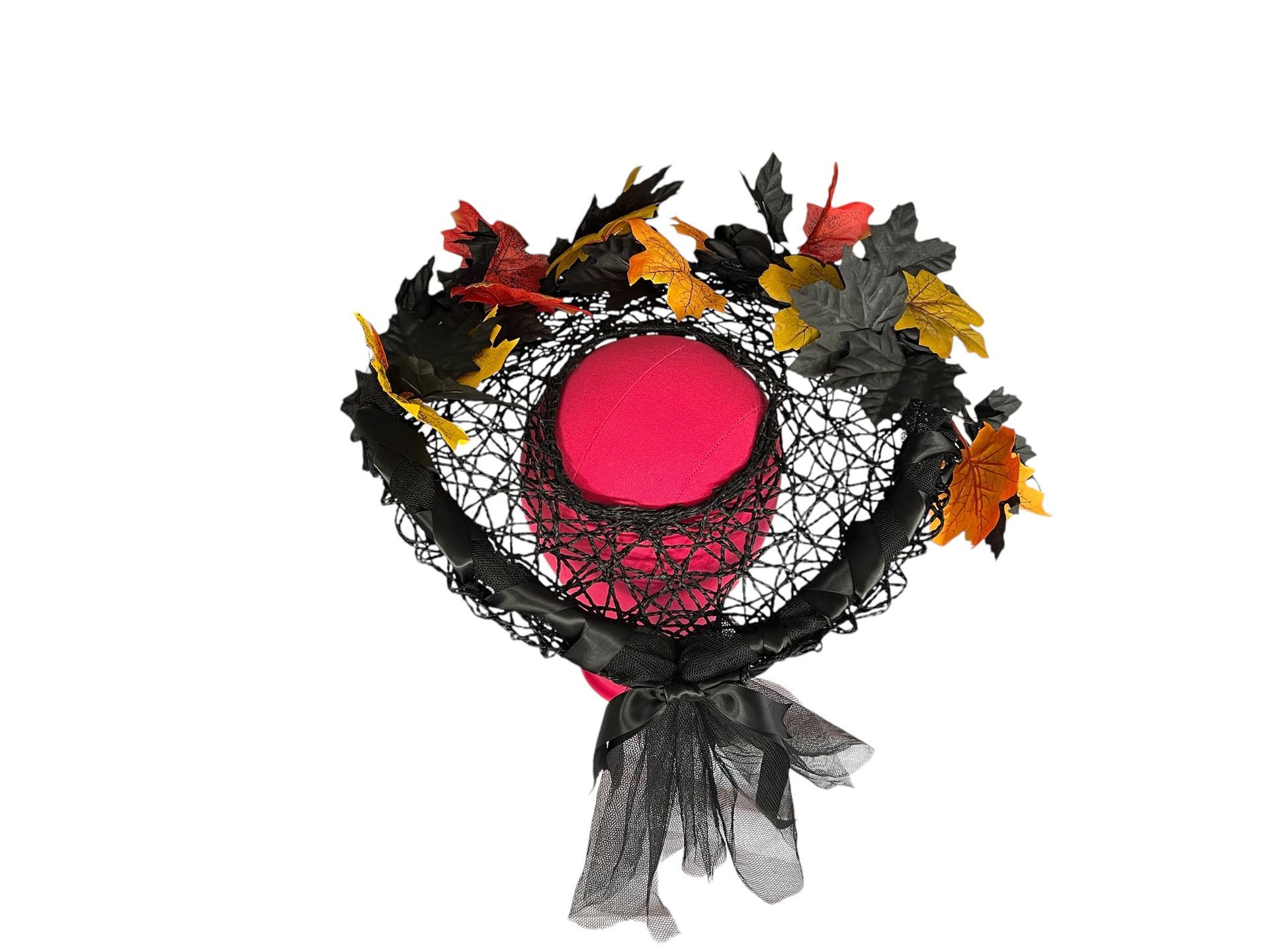 Woman in black dress wearing a black and orange leaf headpiece outdoors in autumn