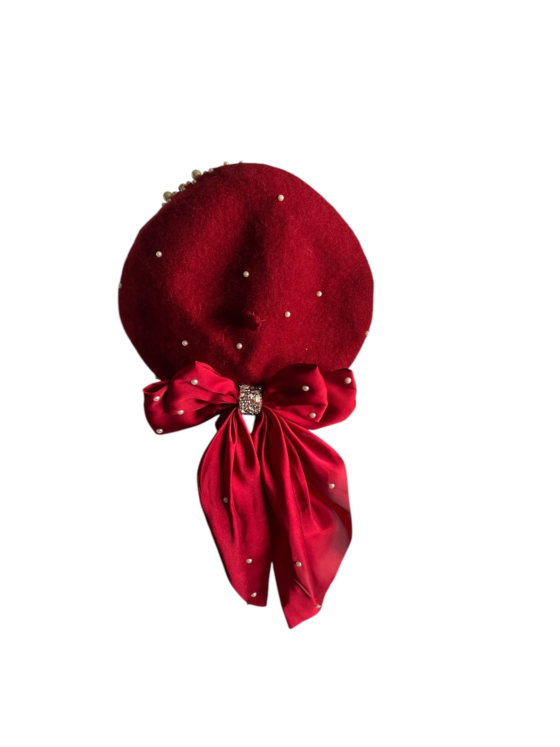 Three decorative hats in gold, red, and silver with matching ribbon bows