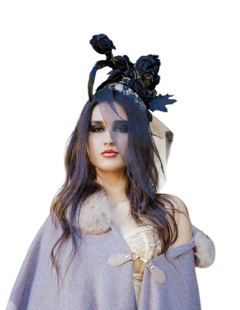 Woman in lavender dress with dark floral headpiece and veil, looking forward against a white background