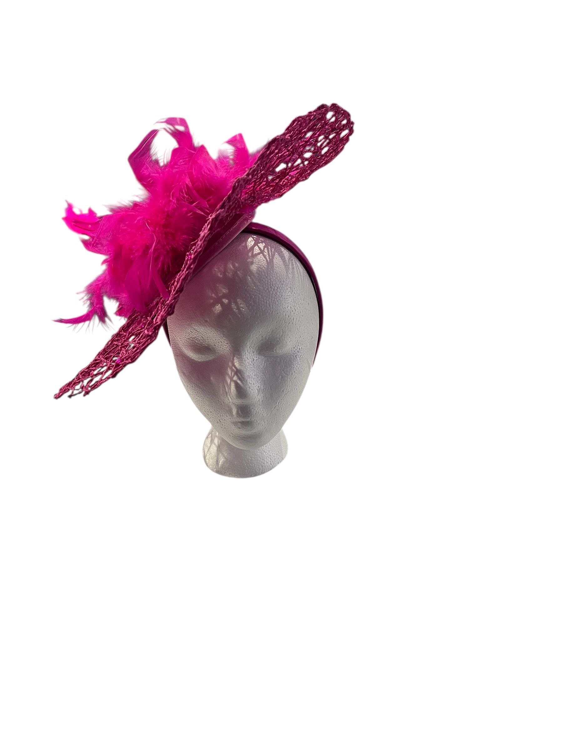 Hot pink, lace-like fascinator hat with a white base on a plain background