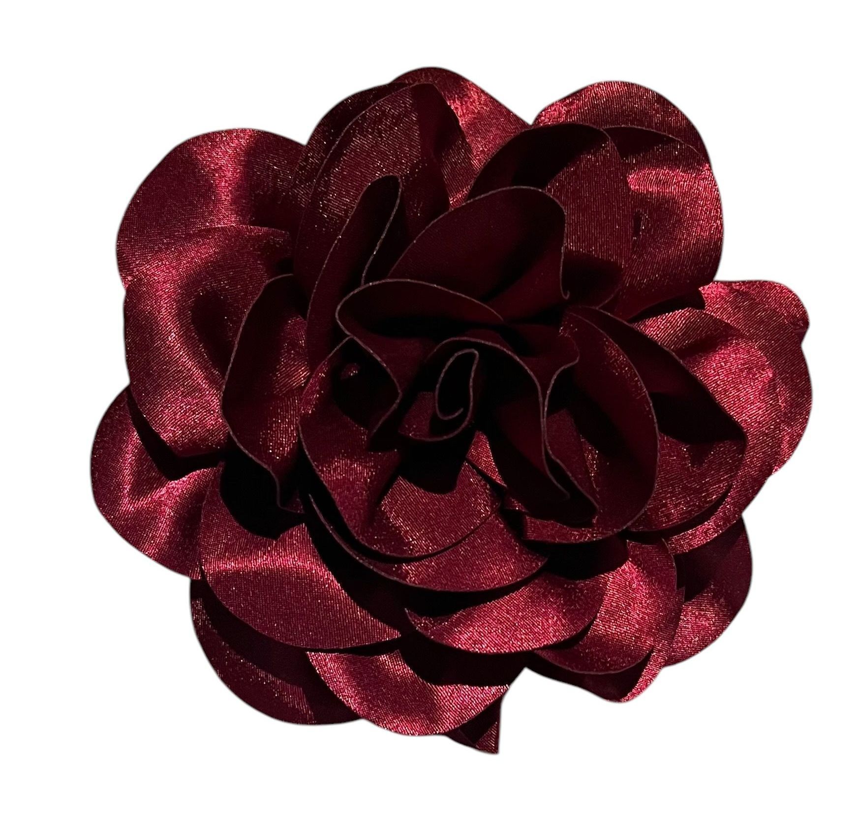 Dark red satin ribbon flower brooch on a white background