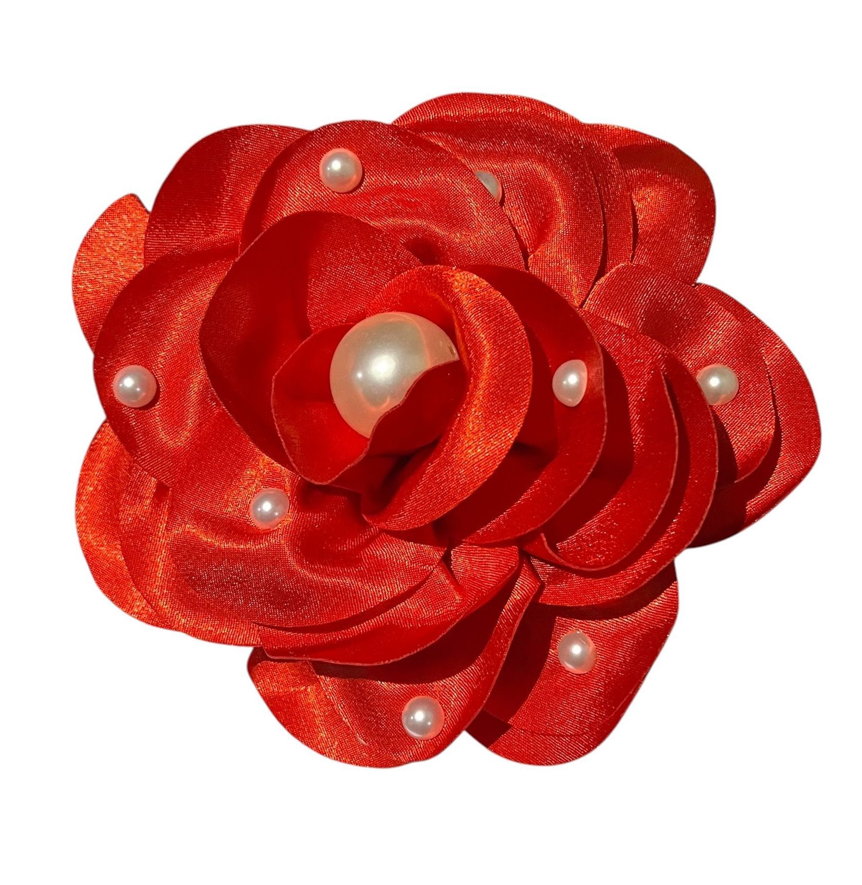 Red satin flower brooch with pearl accents on a white background