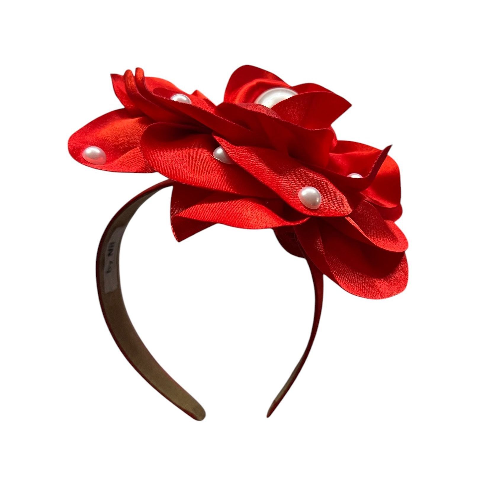 Red satin flower brooch with pearl accents on a white background