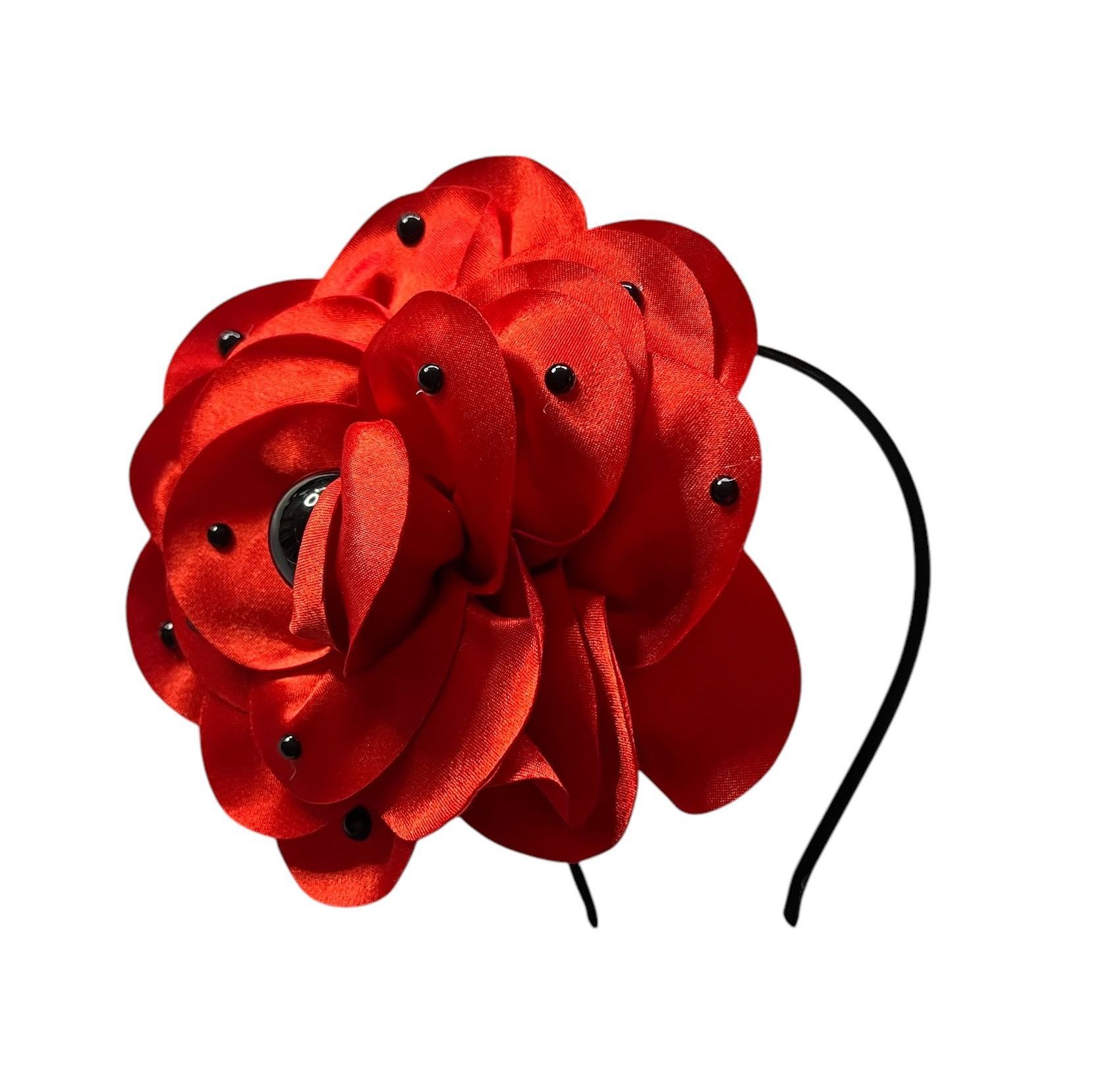 Red fabric flower with black sequins and a dark center on a white background