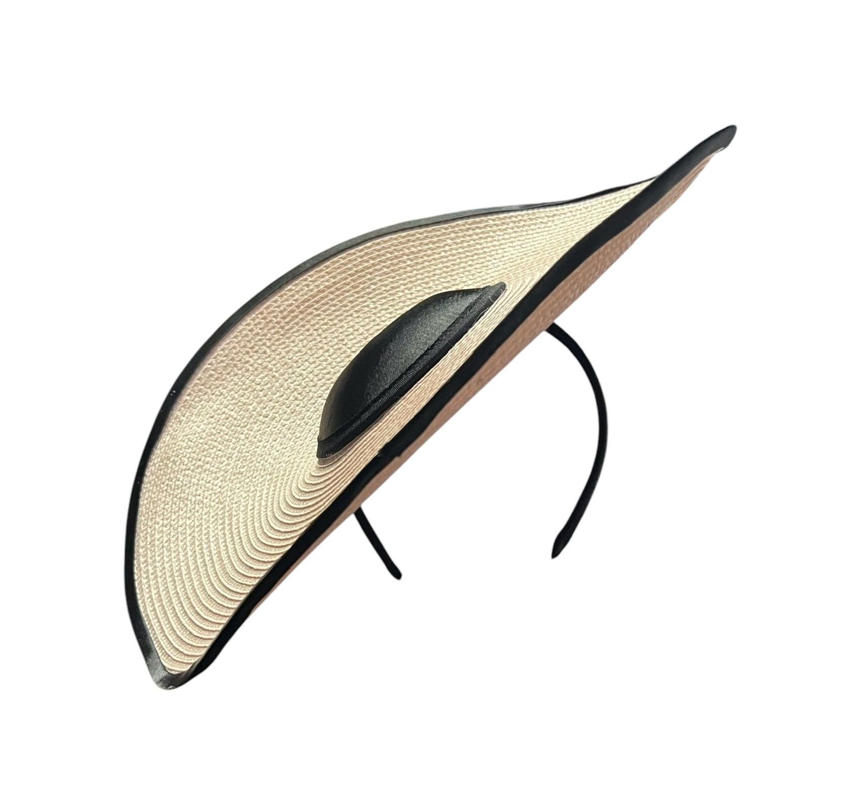 Beige woven sun hat with a black band and round black crown, viewed at an angle