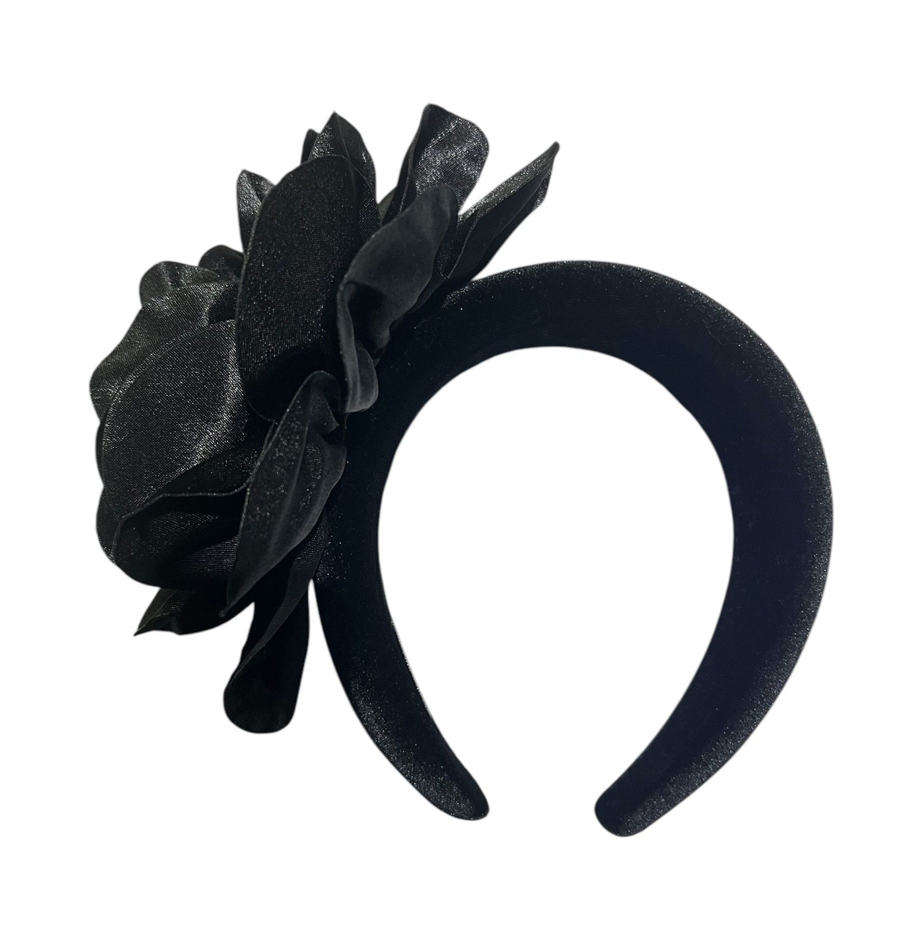 Black fabric flower with layered petals on a white background