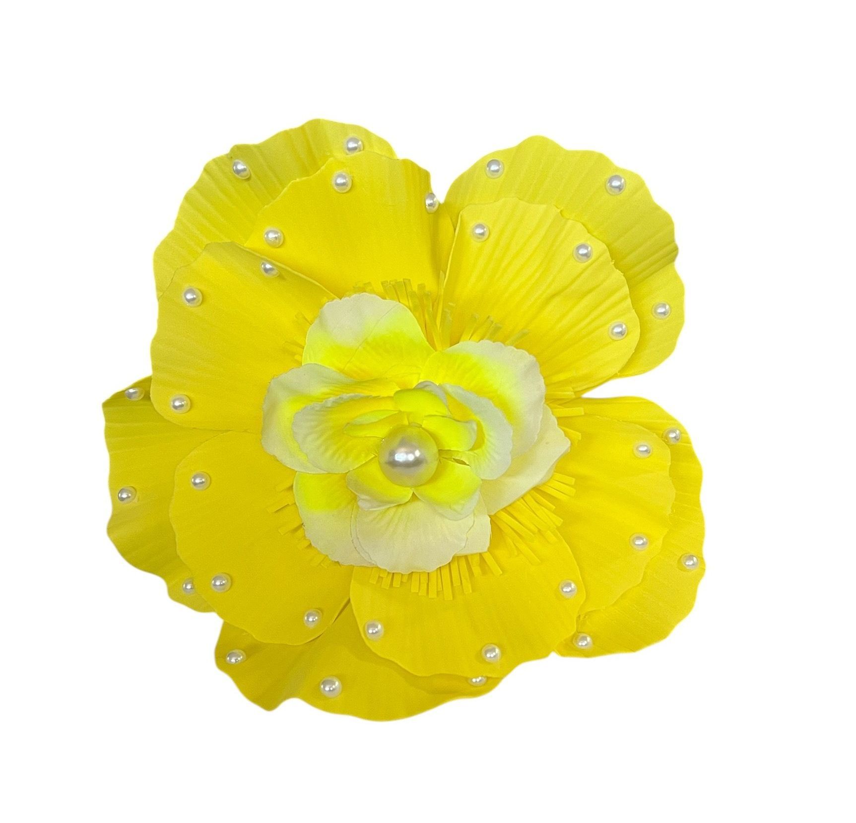 Yellow flower with layered petals and small pearl-like accents on a white background