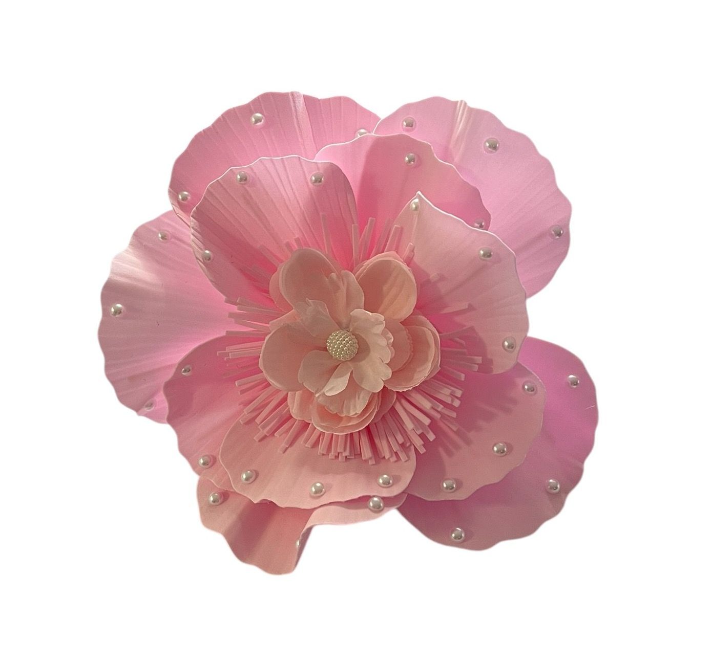 Pink flower with layered petals and pearl-like beads on a white background
