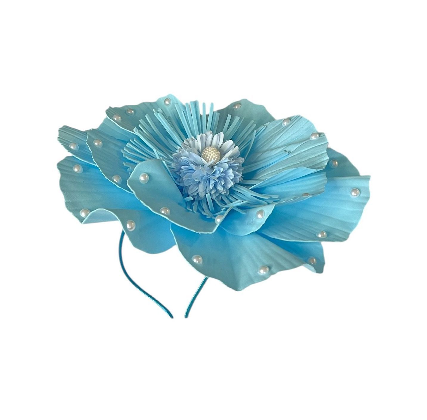 Blue flower with layered petals and beaded center on a white background