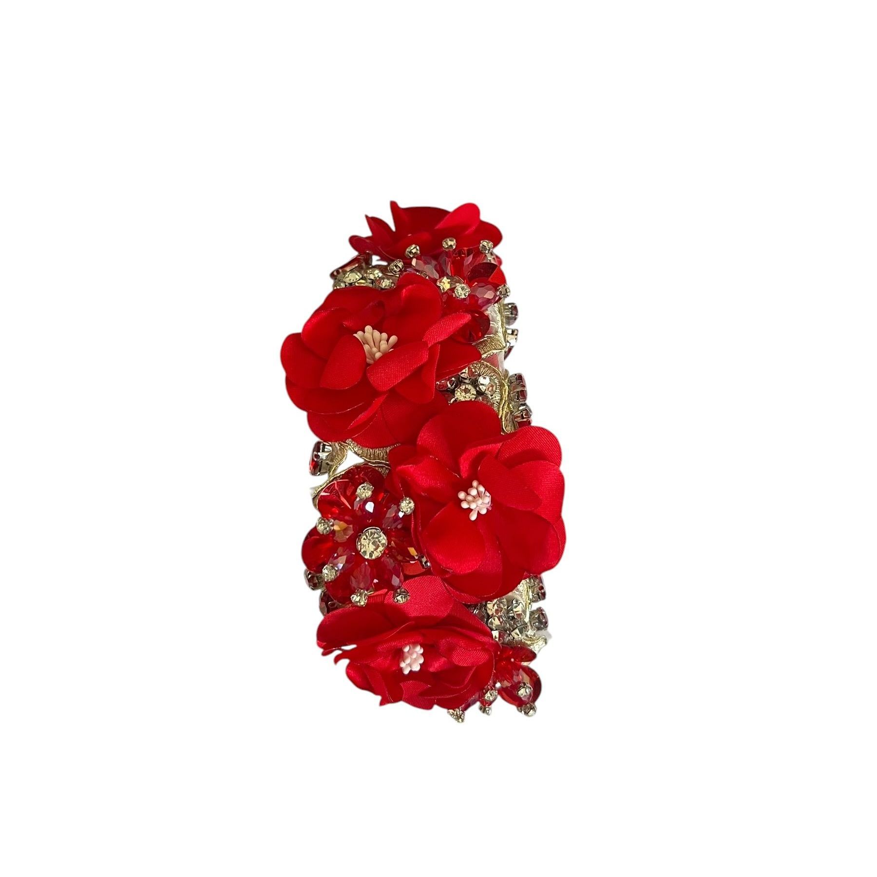 Red floral jeweled bracelet with gold accents on a white background