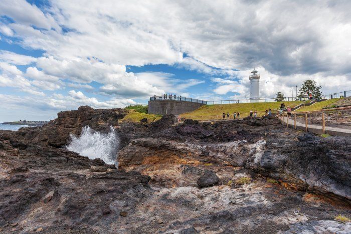 A Lighthouse Is Sitting On Top Of A Rocky Hill Next To A Body Of Water — Sal's Excavations In Kiama, NSW