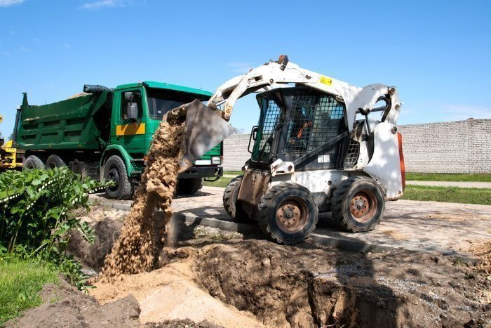 A Bulldozer Is Loading Dirt Into A Dump Truck — Sal's Excavations In St. Georges Basin, NSW