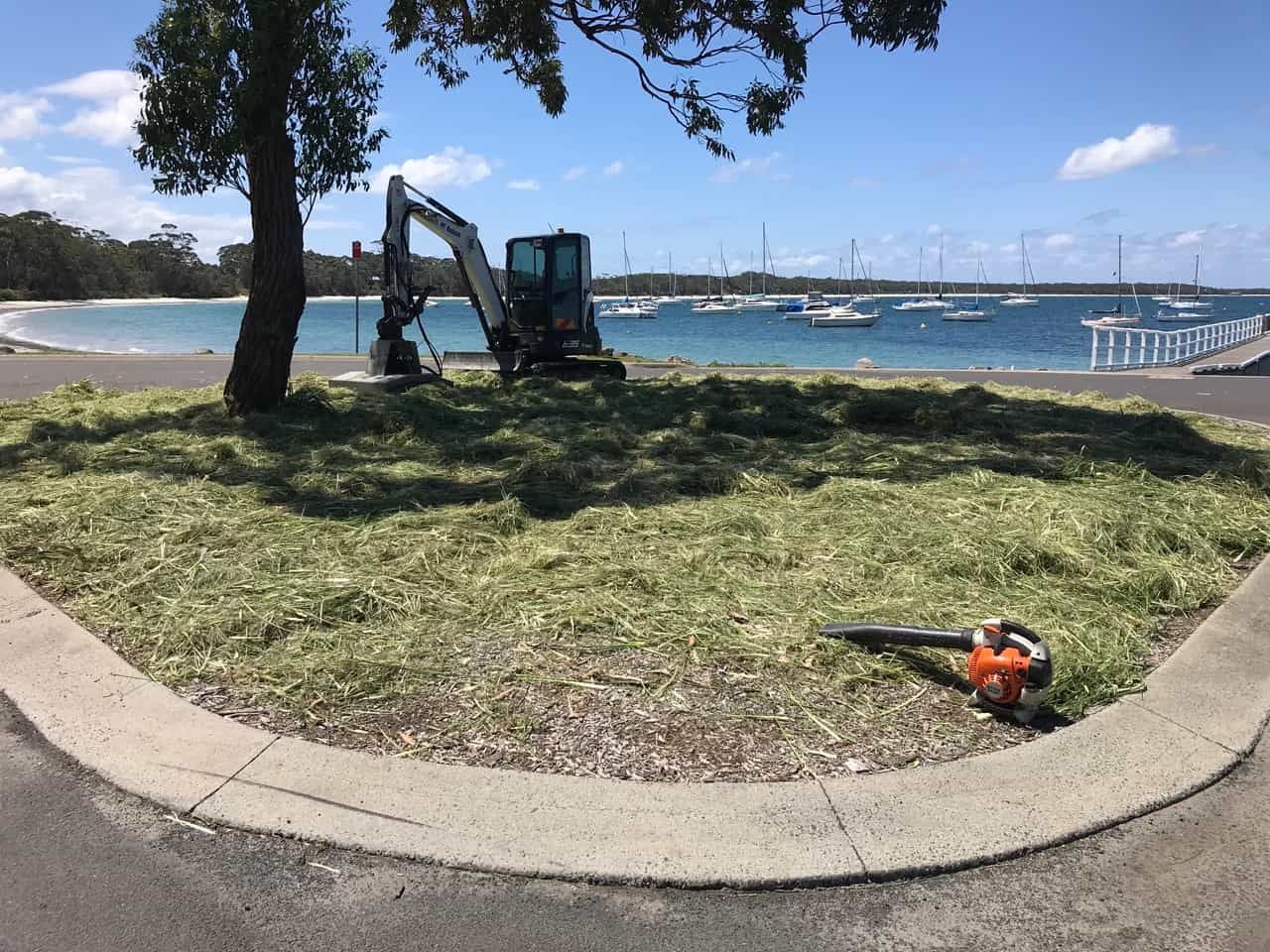 A Lawn Mower Sitting On The Ground In Front Of A Body Of Water — Sal's Excavations In Falls Creek, NSW