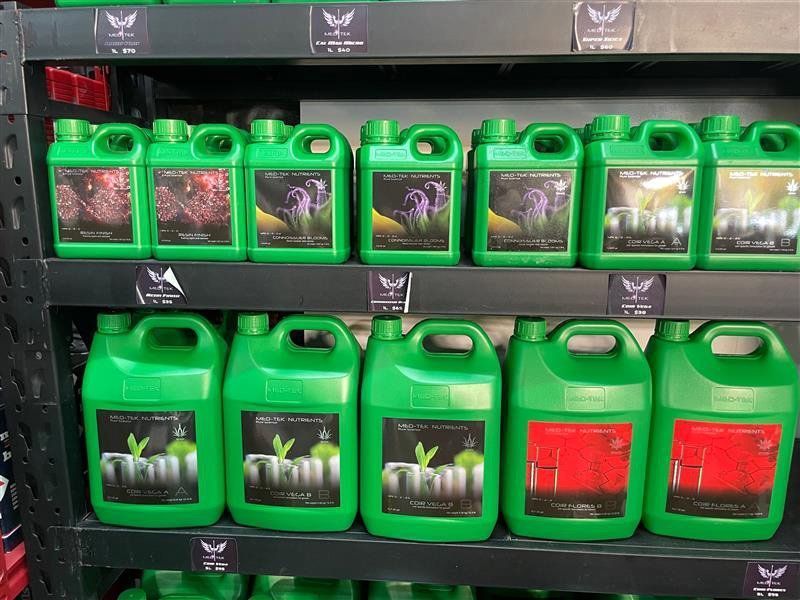 Shelves of Green Liquid Plant Fertilizer Bottles With Colourful Labels in a Store — Cairns Hydroponics In Bungalow, QLD