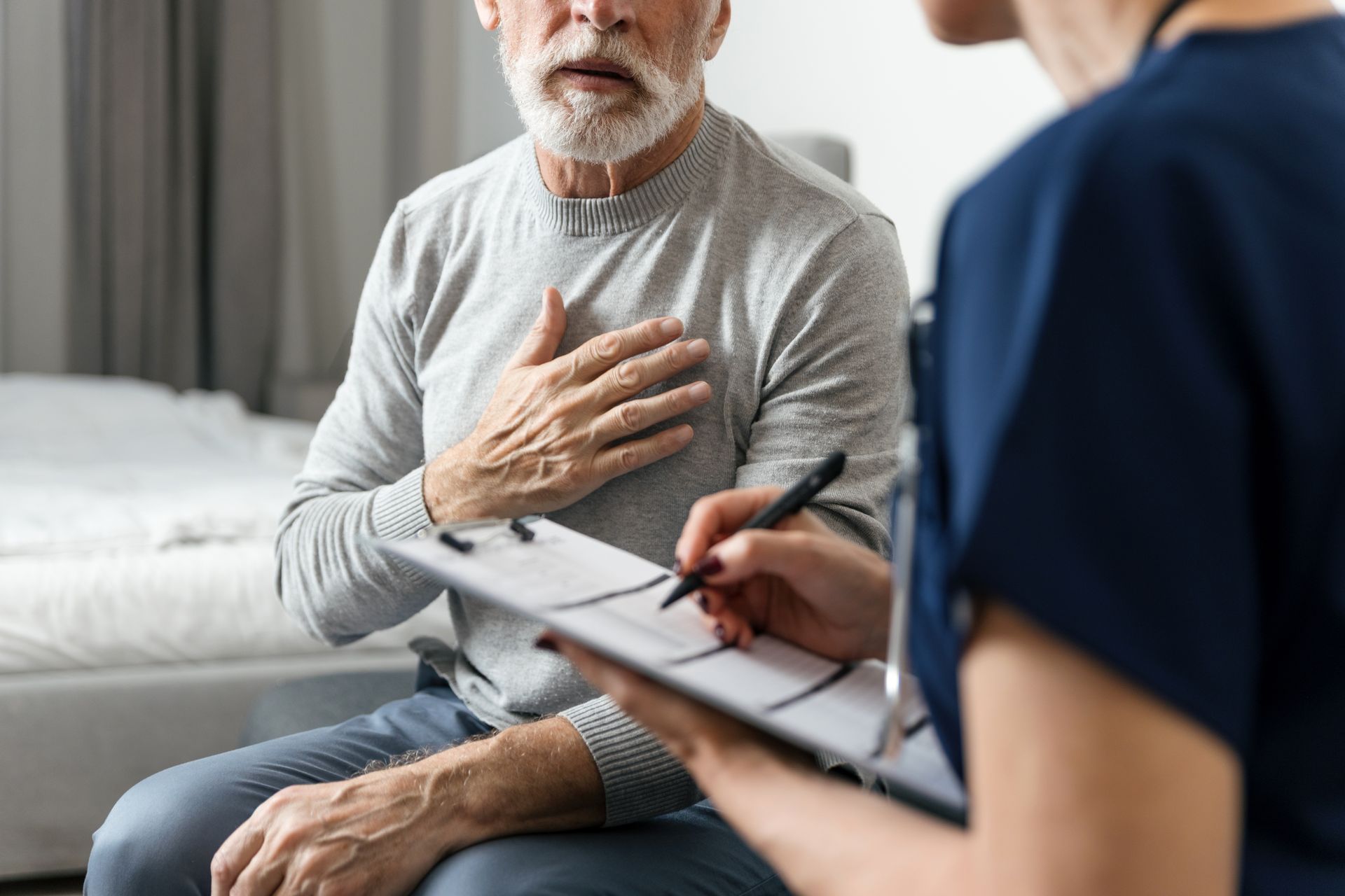Patient holding chest while clinician takes notes in a therapy session