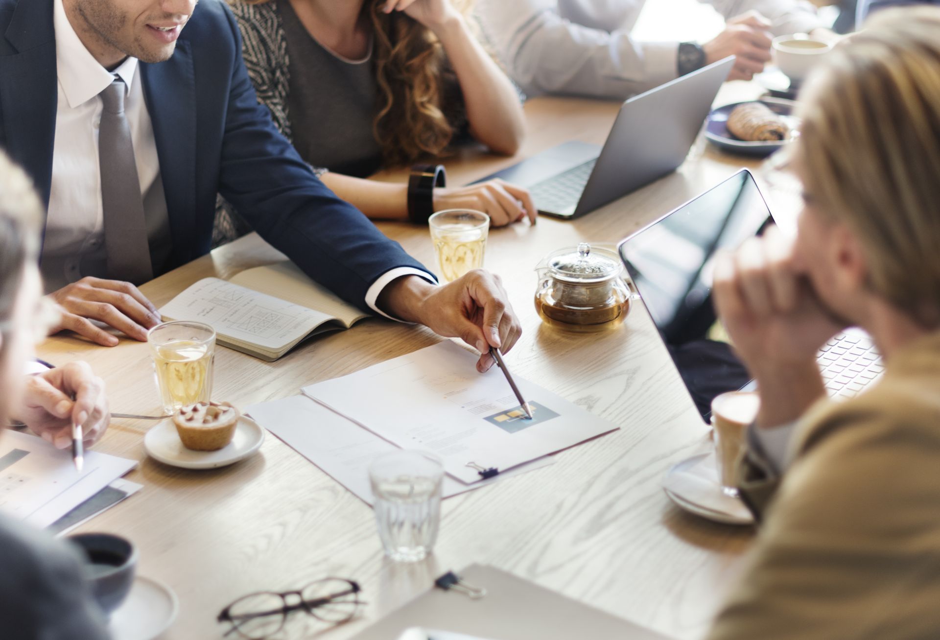A group of people are sitting around a table having a meeting.