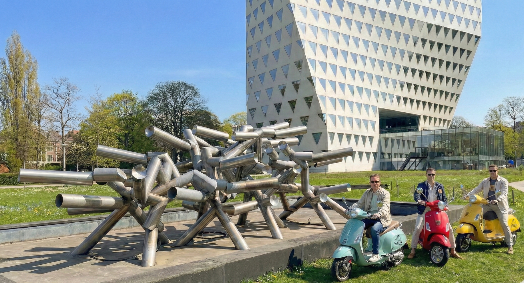 Three people on scooters in front of a metal sculpture and modern building.