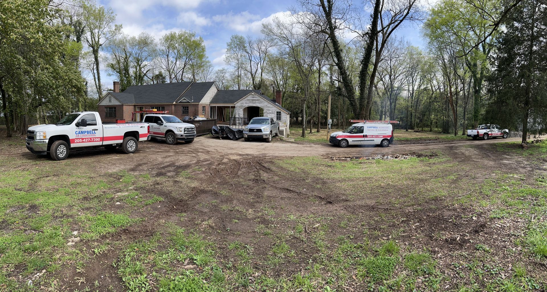 Vehicles and a house in an outdoor setting. Emergency response vehicles and tow truck present.