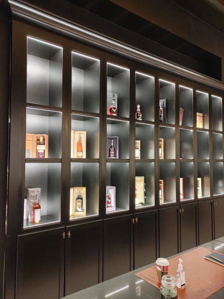 Glass display cabinets with lit shelves and bottled products in a modern store interior