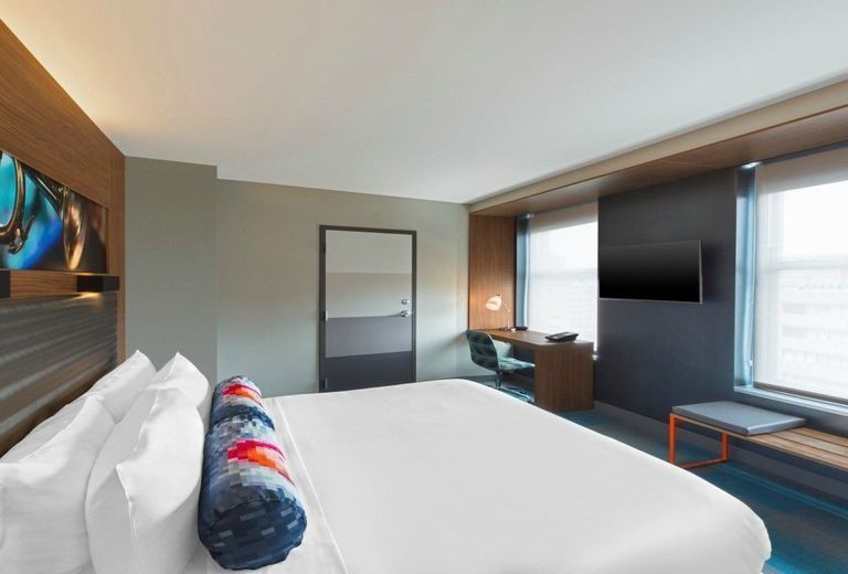 A hotel room with a king size bed and a flat screen tv.