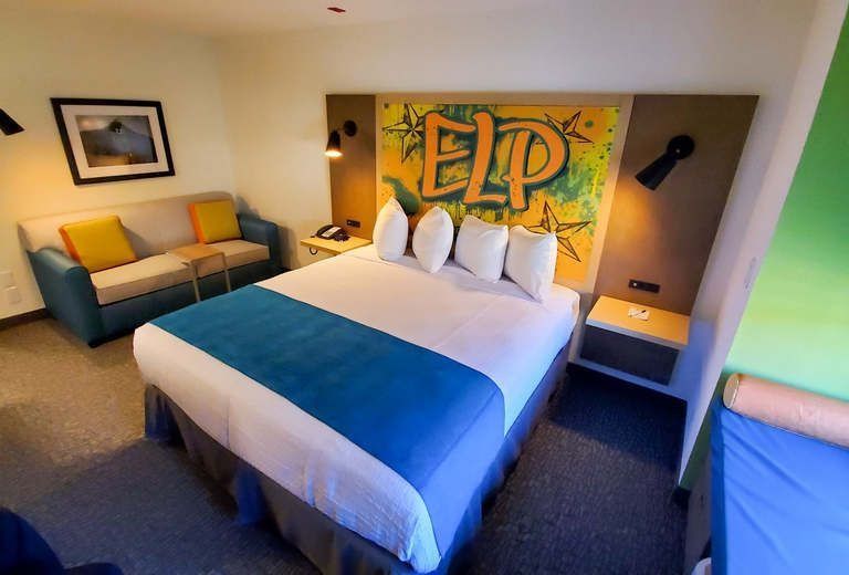 A hotel room with a king size bed and a couch.