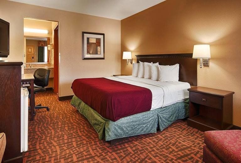 A hotel room with a king size bed and a television.