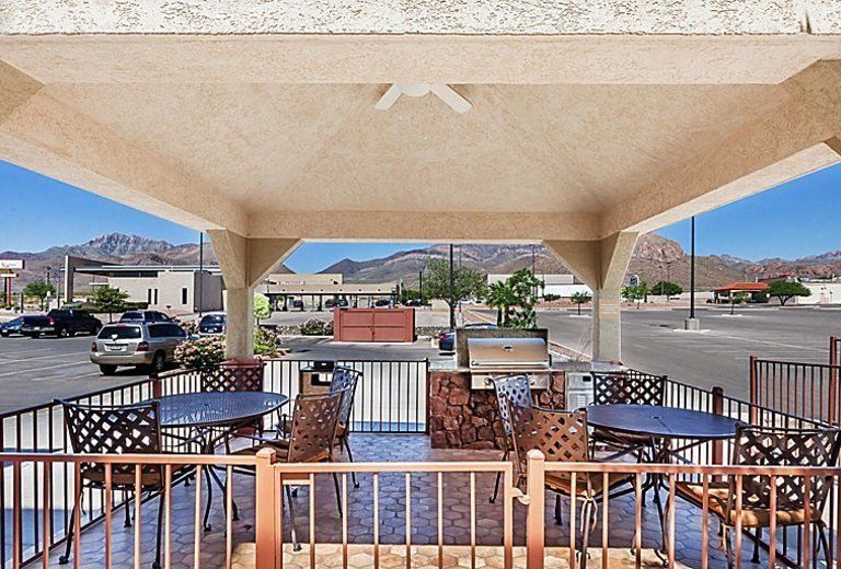 A gazebo with tables and chairs and a grill