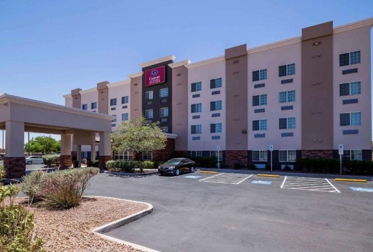 A large hotel with a car parked in front of it