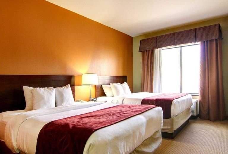 A hotel room with two beds and a window
