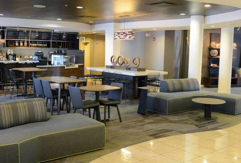 A hotel lobby with tables and chairs and a couch.