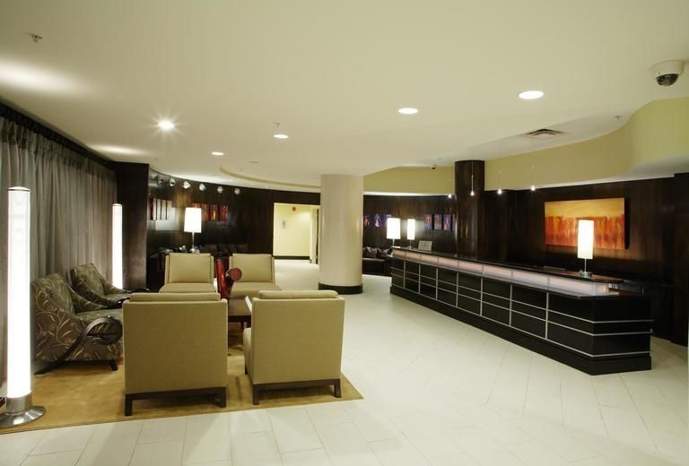 A lobby of a hotel with chairs and a counter