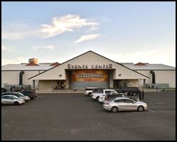 A large white building with a lot of cars parked in front of it.