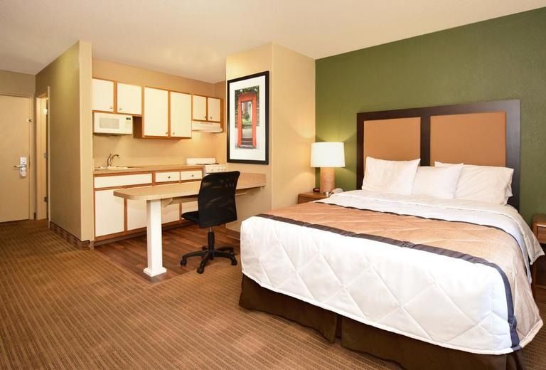 A hotel room with a king size bed and a desk