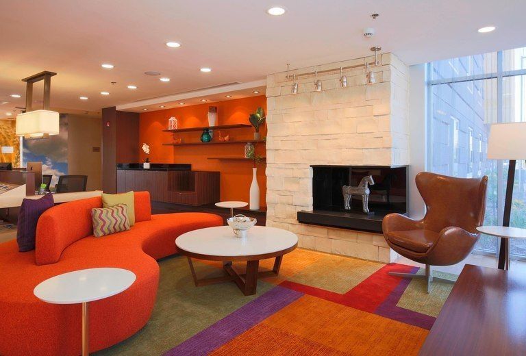A living room with a couch , chair , table and fireplace.