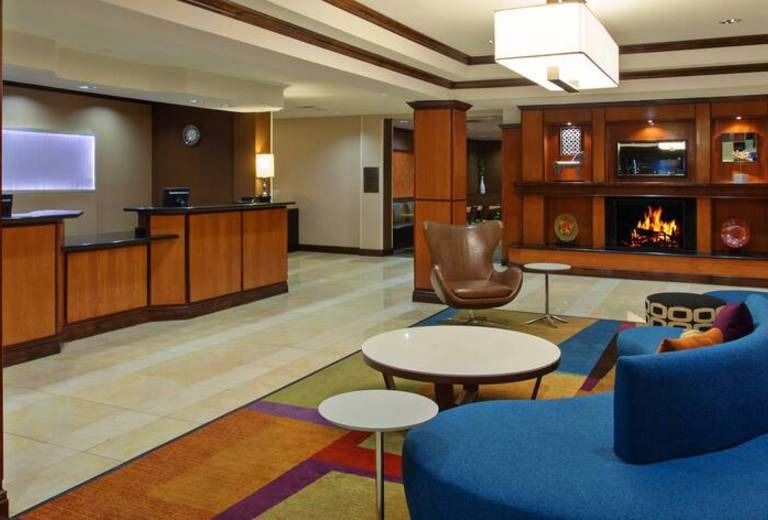 A hotel lobby with a blue couch and a fireplace