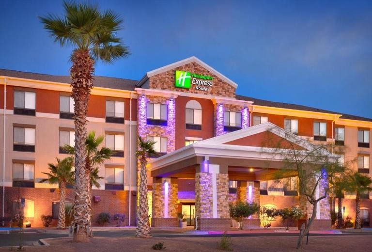A large hotel with palm trees in front of it