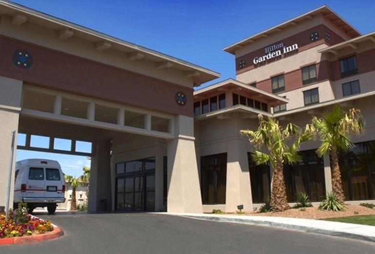 A white van is parked in front of the garden inn